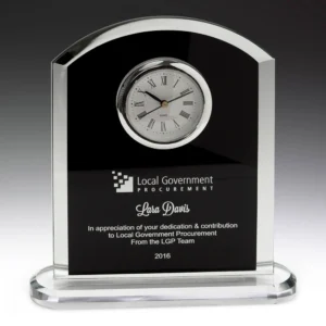 Black glass arch desk clock with roman numeral dial, clear glass edges and engraved presentation panel on a glass base