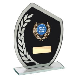 Black glass shield award with silver edge trim, large frosted laurel leaf detail on left, circular gold laurel logo insert at centre, and gold engraving plate on clear glass base.