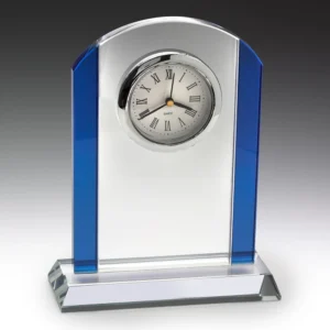 Blue glass desk clock with clear centre panel and round face with roman numerals on a glass base