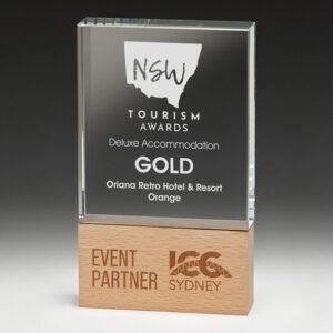 Clear glass corporate awards trophy with engraved tourism text mounted on natural timber base