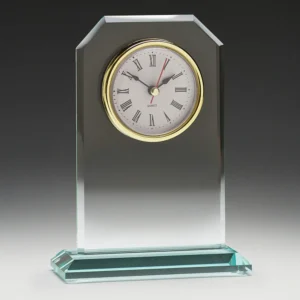 Clear glass desk clock with bevelled edges and round face with roman numerals on a glass base