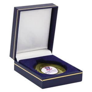 Navy blue medal display case with gold edging and white satin interior, featuring a round custom logo insert medal secured in a fitted velvet foam base.