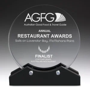 Round clear glass award with engraved restaurant awards text mounted on black base with metal supports