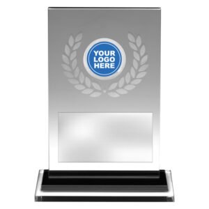 Silver glass award plaque with frosted laurel wreath design, circular logo insert at top centre, and rectangular engraving plate on black base.
