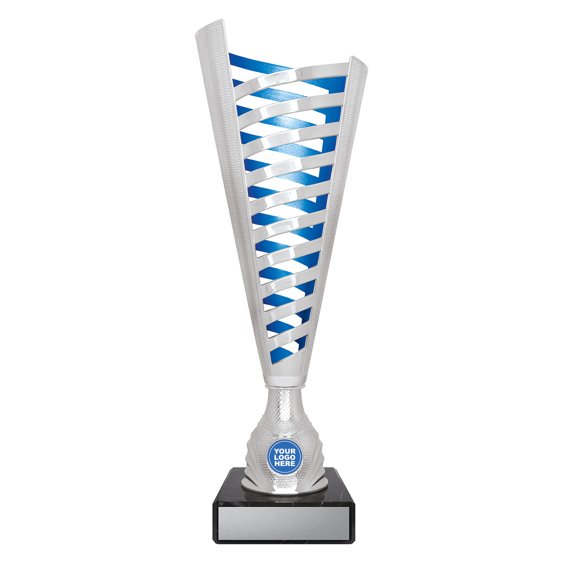 Large tall silver cup trophy with vertical cutout lattice design, blue inner panel detail, round logo insert holder and black marble base with engraving plate.