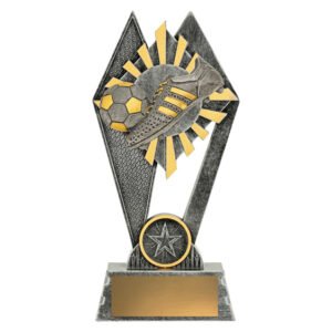 Small silver and gold soccer trophy with boot and ball over sunburst design inside diamond frame on rectangular base.
