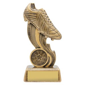 Small antique gold soccer trophy featuring detailed football boot above curved swoosh design, round star emblem insert and gold engraving plate on textured base.