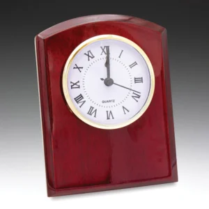 Wooden desk clock with curved red finish and round white face with roman numerals