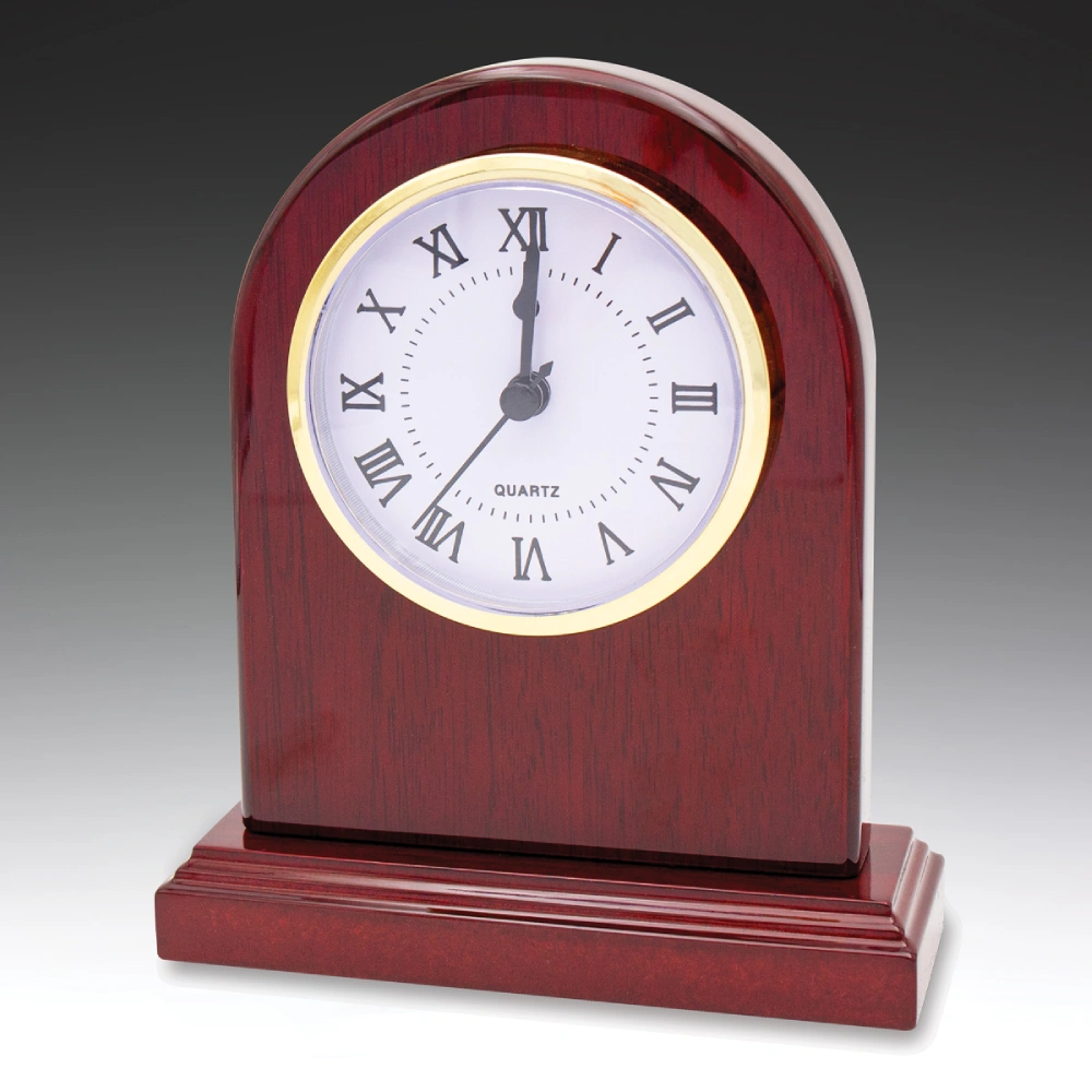 Arched wooden desk clock with red finish and white face with roman numerals on a stepped base