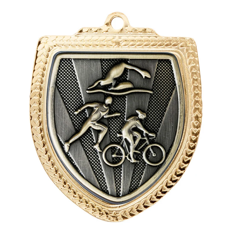 Gold triathlon shield medal with swimmer cyclist and runner figures on textured background